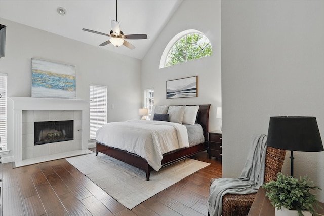 14620 Windsor Ct, Addison, TX 75001 - bedroom featuring high vaulted ceiling, a tiled fireplace, wood finished floors, and ceiling fan