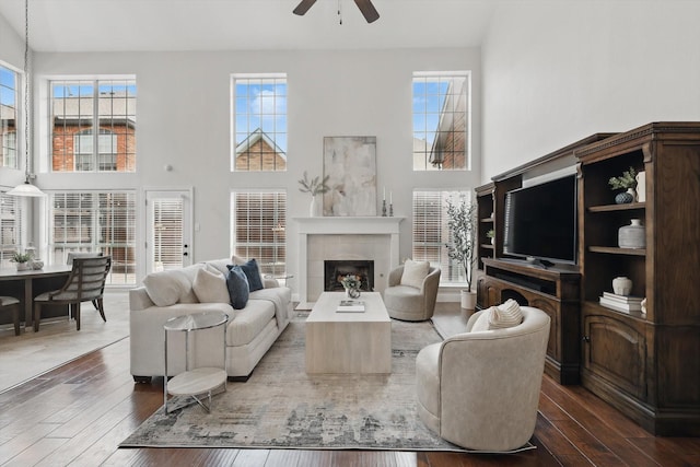 14620 Windsor Ct, Addison, TX 75001 - living room featuring ceiling fan, a towering ceiling, hardwood / wood-style flooring, a fireplace, and plenty of natural light
