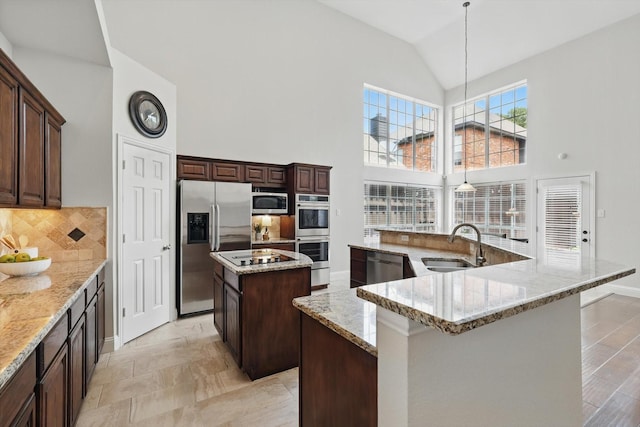 14620 Windsor Ct, Addison, TX 75001 - kitchen featuring a large island, stainless steel appliances, a sink, high vaulted ceiling, and decorative backsplash