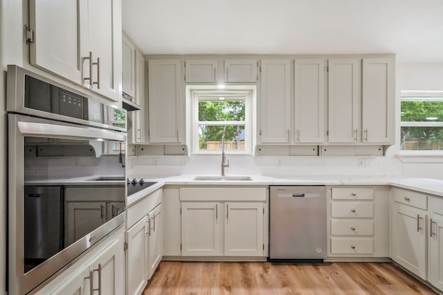 436 Crestwood Ter, Hurst, TX 76053 - kitchen with appliances with stainless steel finishes, a sink, light countertops, and light wood finished floors