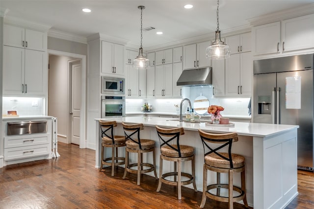 6242 Vickery Blvd, Dallas, TX 75214 - kitchen featuring appliances with stainless steel finishes, a warming drawer, under cabinet range hood, decorative backsplash, and light countertops