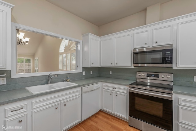 10085 Baldwin Ct, Shreveport, LA 71115 - kitchen featuring stainless steel appliances, a sink, a chandelier, white cabinets, and light wood-style floors