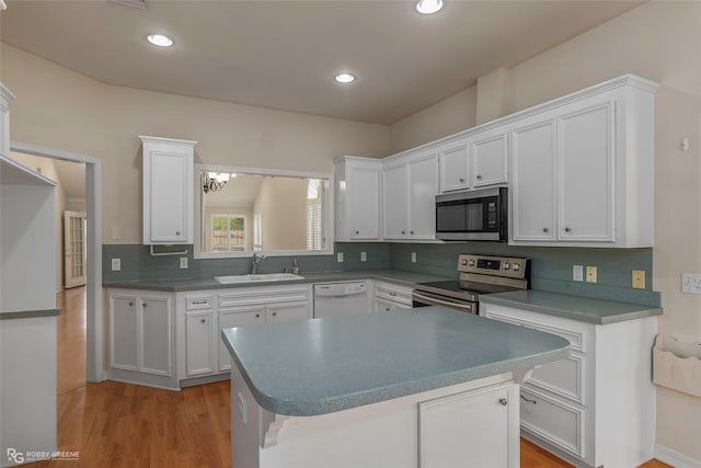 10085 Baldwin Ct, Shreveport, LA 71115 - kitchen featuring appliances with stainless steel finishes, a sink, white cabinetry, light wood finished floors, and recessed lighting