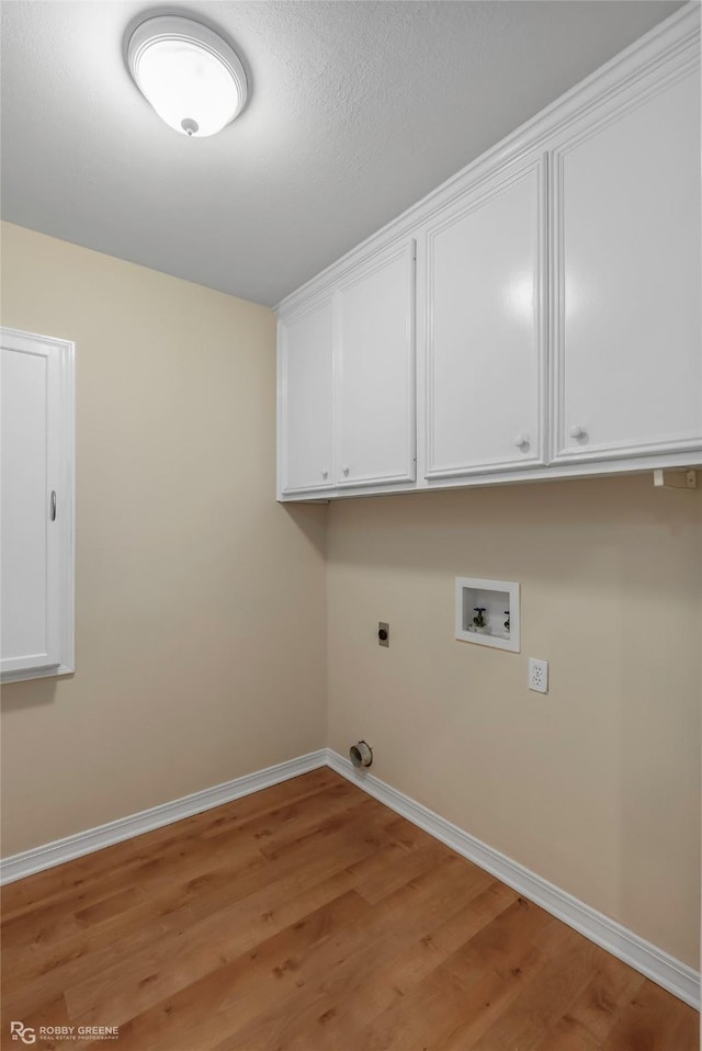 10085 Baldwin Ct, Shreveport, LA 71115 - washroom featuring baseboards, electric dryer hookup, hookup for a washing machine, light wood-style floors, and cabinet space