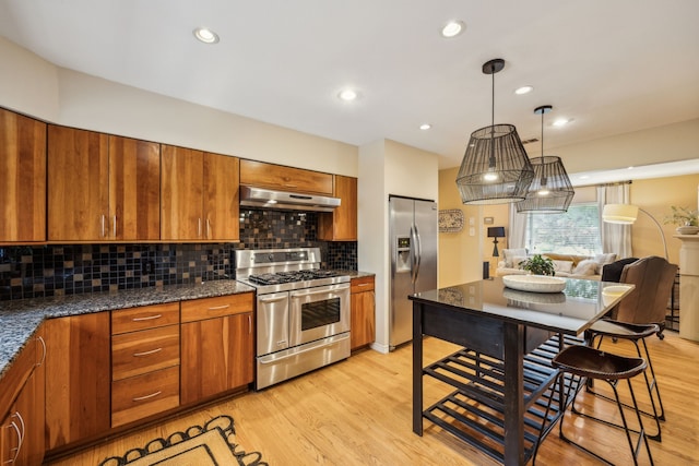 9834 Carnegie Dr, Dallas, TX 75228 - kitchen featuring appliances with stainless steel finishes, under cabinet range hood, brown cabinets, tasteful backsplash, and recessed lighting