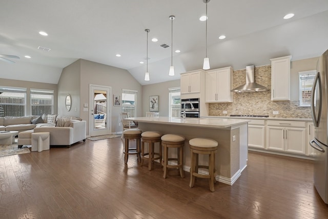2837 Redbud Ln, Melissa, TX 75454 - kitchen with wall chimney range hood, vaulted ceiling, healthy amount of natural light, dark wood-style flooring, and stainless steel appliances