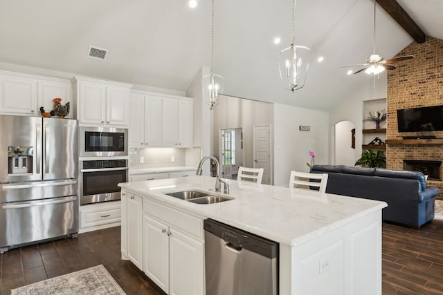 8900 Hidden Pond St, Justin, TX 76247 - kitchen featuring appliances with stainless steel finishes, a sink, open floor plan, dark wood-type flooring, and ceiling fan
