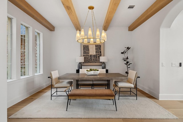 6405 Rockbluff Cir, Plano, TX 75024 - dining room featuring plenty of natural light, arched walkways, a chandelier, wood finished floors, and beamed ceiling