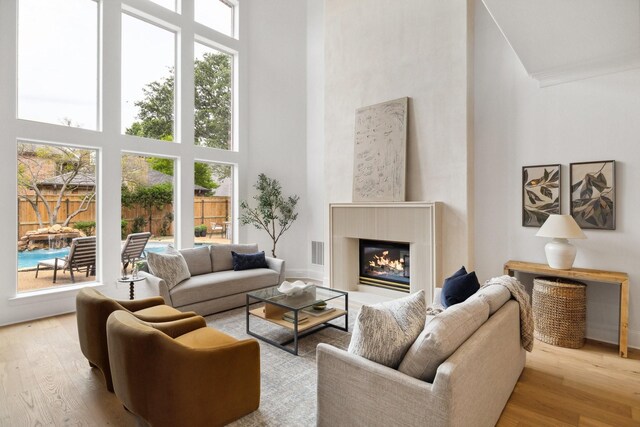 6405 Rockbluff Cir, Plano, TX 75024 - living area featuring a high ceiling, crown molding, arched walkways, light wood-style flooring, and a fireplace