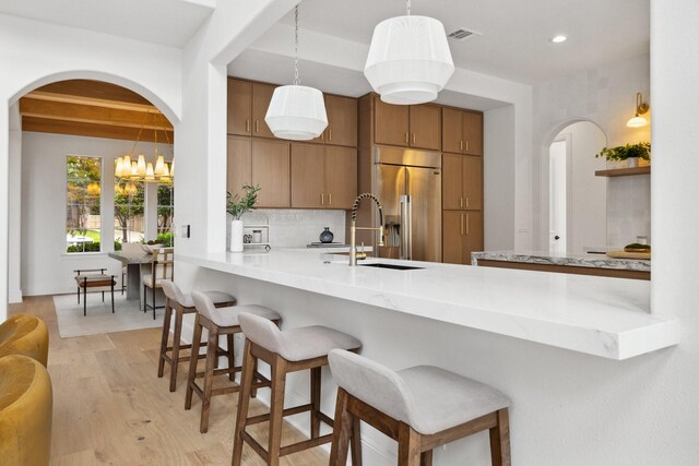 6405 Rockbluff Cir, Plano, TX 75024 - kitchen with high quality fridge, arched walkways, a peninsula, beam ceiling, and recessed lighting