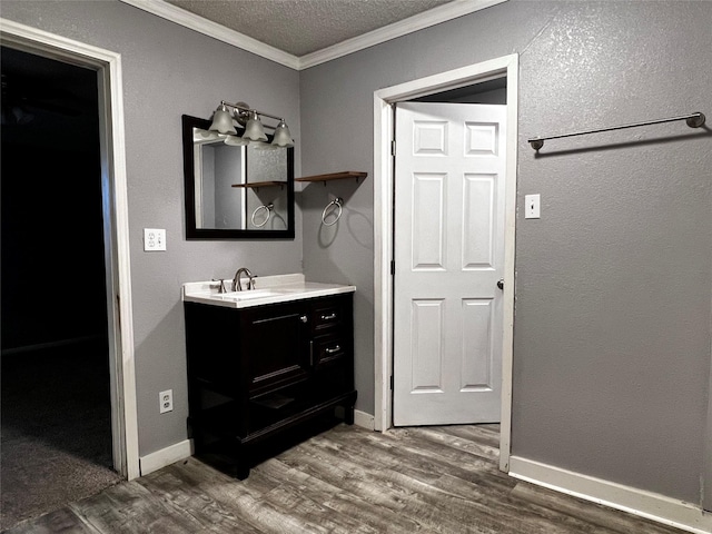 106 Lane St, Comanche, TX 76442 - bathroom with ornamental molding, vanity, wood finished floors, a textured ceiling, and baseboards