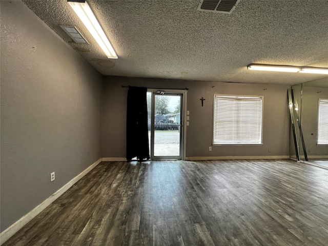 106 Lane St, Comanche, TX 76442 - unfurnished room featuring a textured ceiling, dark wood finished floors, and baseboards