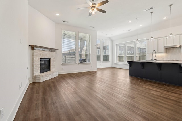 2208 13th St, Argyle, TX 76226 - unfurnished living room with ceiling fan, recessed lighting, dark wood-type flooring, baseboards, and a brick fireplace