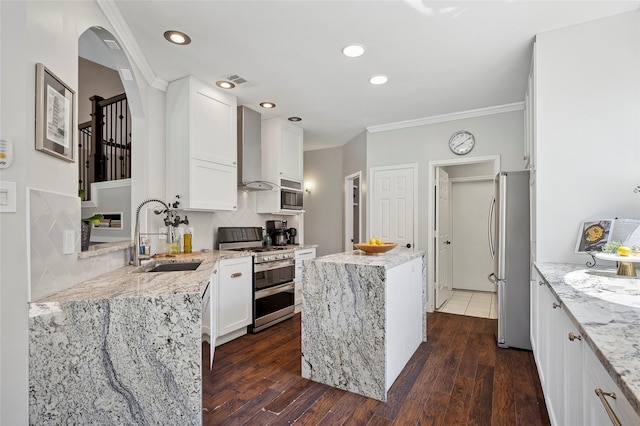 2201 Heatherton Pl, Plano, TX 75023 - kitchen featuring appliances with stainless steel finishes, a sink, a kitchen island, wall chimney range hood, and light stone counters