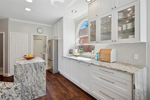 2201 Heatherton Pl, Plano, TX 75023 - kitchen featuring freestanding refrigerator, crown molding, glass insert cabinets, white cabinetry, and backsplash