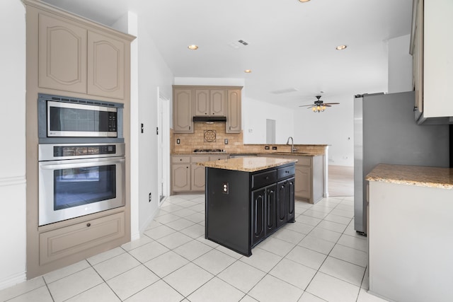 12809 Conifer Ln, Fort Worth, TX 76040 - kitchen featuring appliances with stainless steel finishes, a sink, ceiling fan, a peninsula, and tasteful backsplash