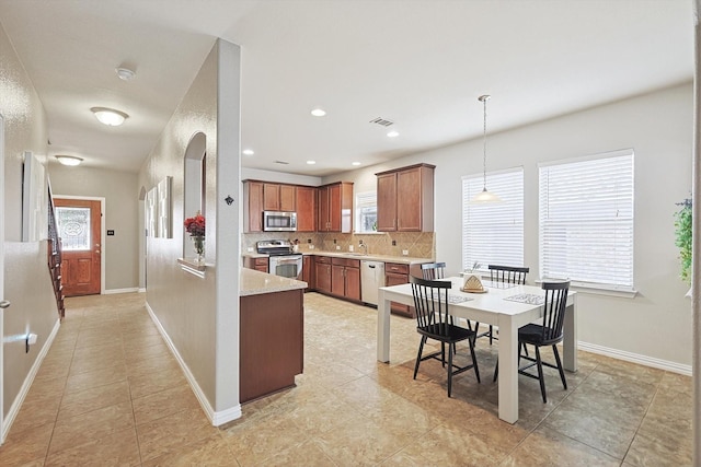 7009 Bishop Pine Rd, Denton, TX 76208 - kitchen with appliances with stainless steel finishes, tasteful backsplash, light countertops, hanging light fixtures, and a sink