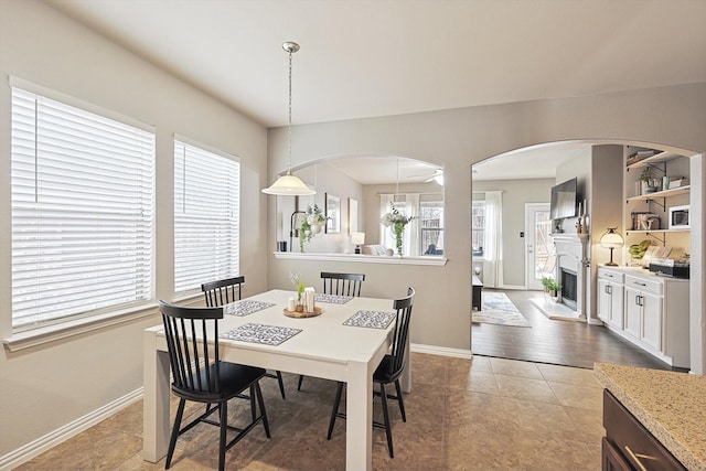 7009 Bishop Pine Rd, Denton, TX 76208 - dining room with baseboards, arched walkways, a fireplace, and tile patterned flooring