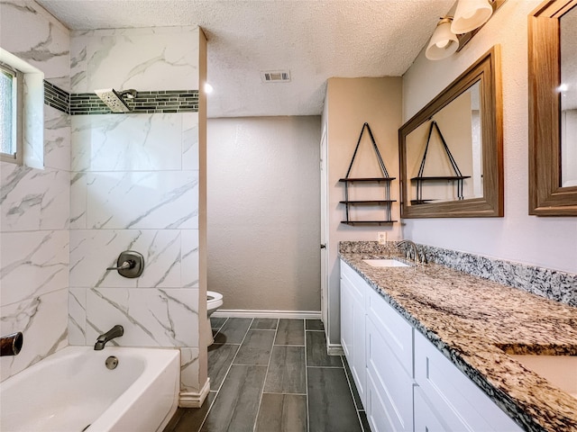 1013 Gannon Dr, Plano, TX 75025 - full bath featuring double vanity, toilet, a textured ceiling, shower / bathtub combination, and baseboards