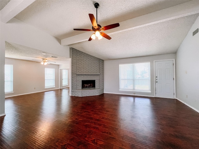 1013 Gannon Dr, Plano, TX 75025 - unfurnished living room with ceiling fan, a textured ceiling, hardwood / wood-style floors, a brick fireplace, and baseboards