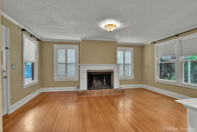 350 Albany Ave, Shreveport, LA 71105 - unfurnished living room with light wood-style floors, crown molding, a textured ceiling, a fireplace with raised hearth, and baseboards