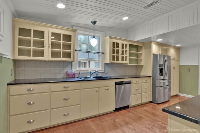 350 Albany Ave, Shreveport, LA 71105 - kitchen with appliances with stainless steel finishes, a sink, cream cabinets, light wood-style floors, and decorative light fixtures