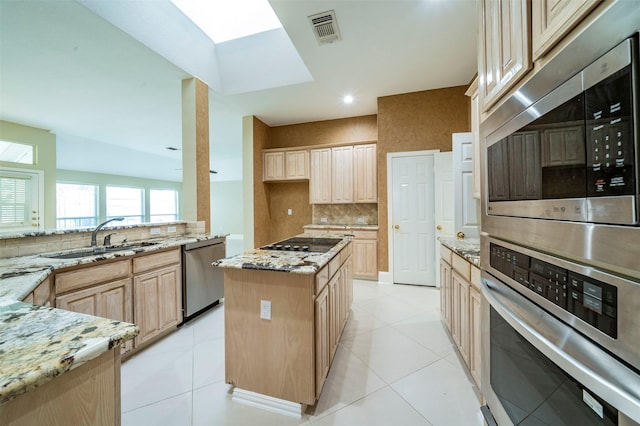 2231 Templeton Dr, Arlington, TX 76006 - kitchen featuring appliances with stainless steel finishes, a sink, light stone counters, backsplash, and light brown cabinetry