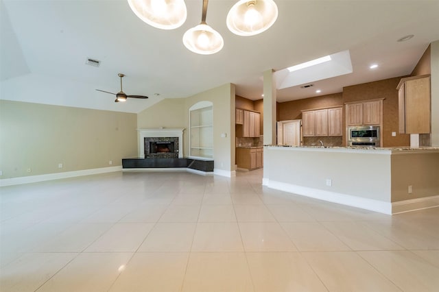 2231 Templeton Dr, Arlington, TX 76006 - unfurnished living room featuring a high end fireplace, ceiling fan, light tile patterned floors, vaulted ceiling, and baseboards