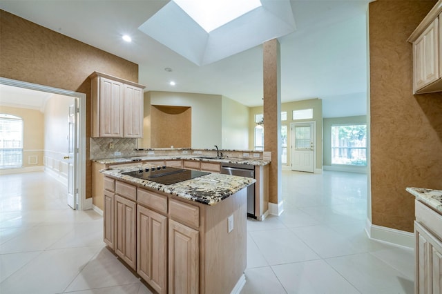 2231 Templeton Dr, Arlington, TX 76006 - kitchen featuring stainless steel dishwasher, black electric cooktop, light brown cabinetry, a sink, and a skylight