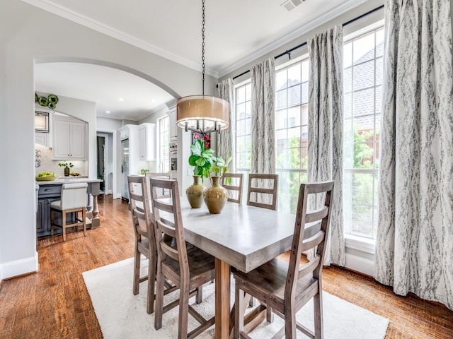 11483 Mirage Ln, Frisco, TX 75033 - dining area featuring ornamental molding, arched walkways, plenty of natural light, light wood-style flooring, and baseboards