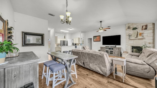 229 Willow Creek Dr, Weatherford, TX 76085 - living room with ceiling fan, light wood-style floors, a chandelier, a fireplace, and vaulted ceiling