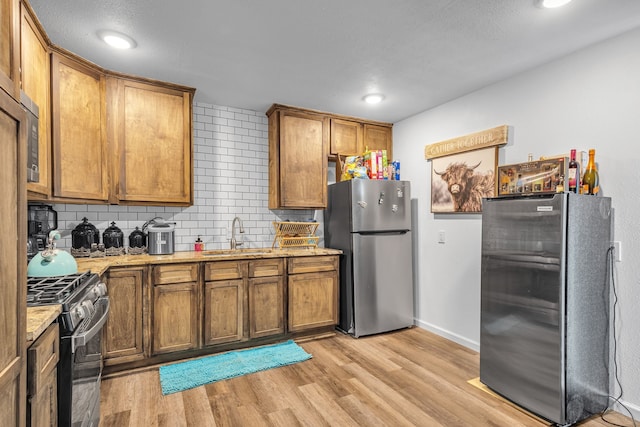 201 E Pearl St, Celeste, TX 75423 - kitchen featuring freestanding refrigerator, a sink, range with gas cooktop, tasteful backsplash, and recessed lighting
