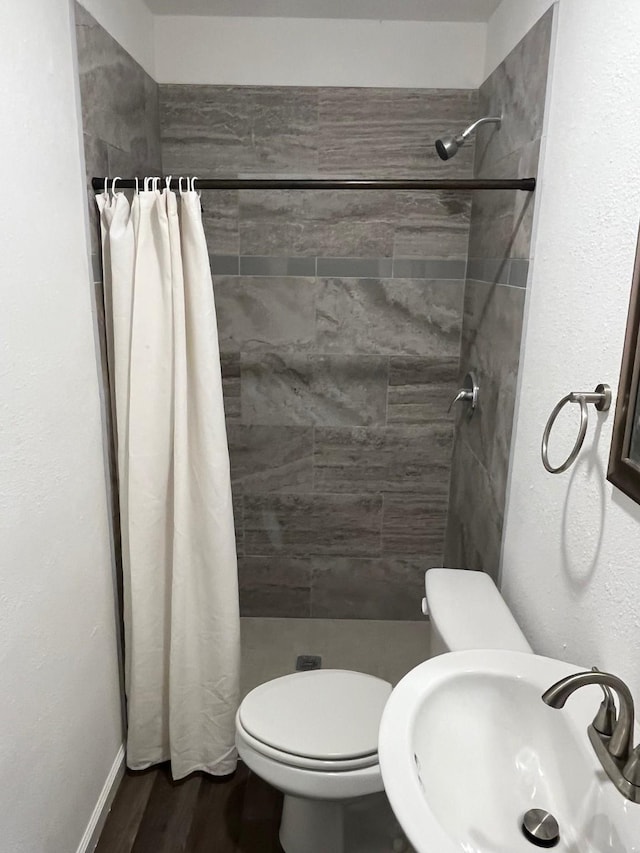 201 E Pearl St, Celeste, TX 75423 - full bathroom with a sink, toilet, a shower stall, and wood finished floors