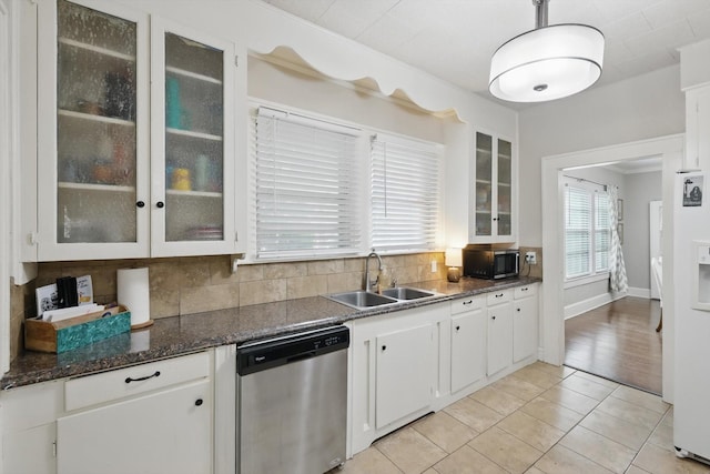 1425 W Gambrell St, Fort Worth, TX 76115 - kitchen featuring stainless steel appliances, a sink, decorative backsplash, white cabinetry, and light tile patterned floors