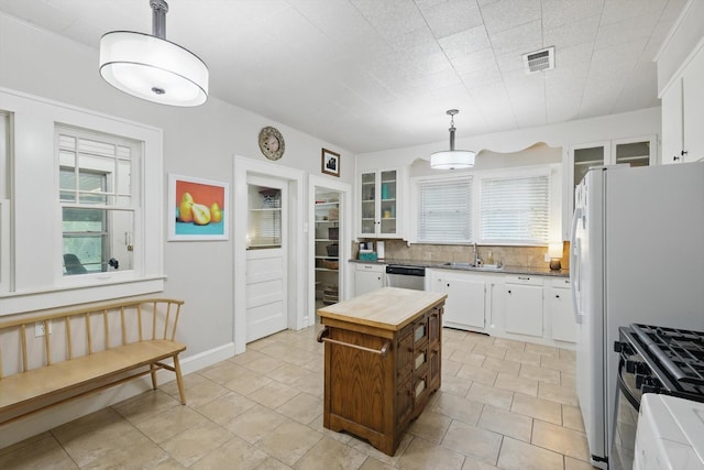 1425 W Gambrell St, Fort Worth, TX 76115 - kitchen featuring a sink, range with gas cooktop, stainless steel dishwasher, white cabinetry, and glass insert cabinets