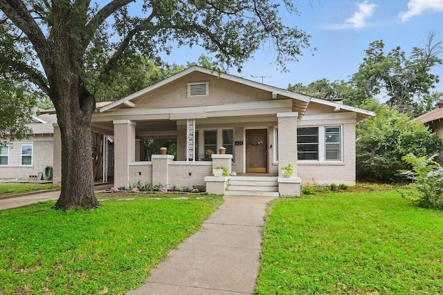 1425 W Gambrell St, Fort Worth, TX 76115 - view of front of property featuring brick siding, a front lawn, and a porch