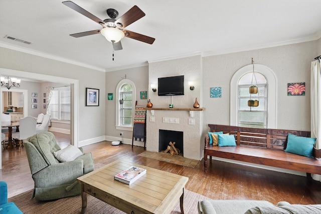 1425 W Gambrell St, Fort Worth, TX 76115 - living area with ornamental molding, wood finished floors, ceiling fan, a chandelier, and a fireplace with flush hearth