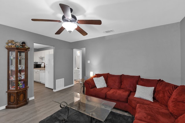704 Windy Hl, Celeste, TX 75423 - living room with light wood-style flooring, baseboards, and a ceiling fan