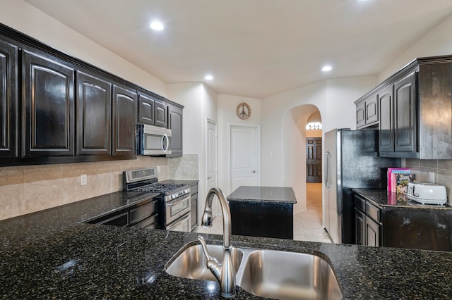 5420 Chinkapin Ln, Fort Worth, TX 76244 - kitchen with stainless steel appliances, a sink, arched walkways, dark stone countertops, and recessed lighting