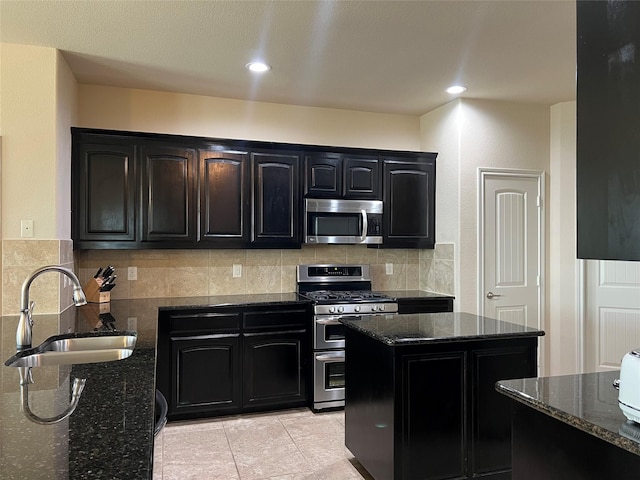 5420 Chinkapin Ln, Fort Worth, TX 76244 - kitchen featuring appliances with stainless steel finishes, a sink, dark stone counters, and dark cabinets