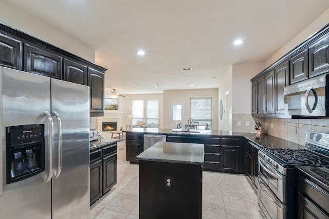 5420 Chinkapin Ln, Fort Worth, TX 76244 - kitchen featuring appliances with stainless steel finishes, a sink, a ceiling fan, a kitchen island, and open floor plan
