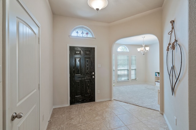 5420 Chinkapin Ln, Fort Worth, TX 76244 - entryway featuring a chandelier, light tile patterned flooring, light colored carpet, arched walkways, and baseboards