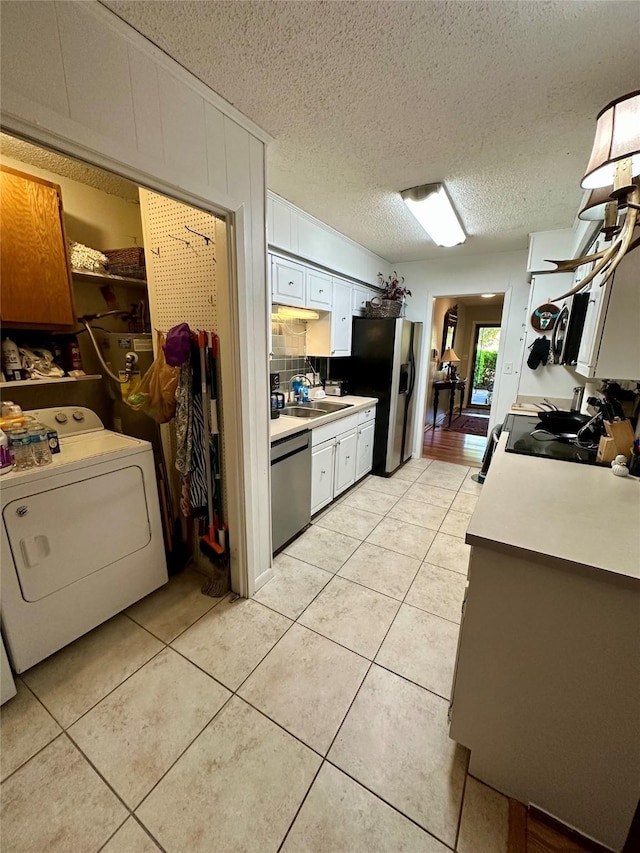 1002 Wrights W, Comanche, TX 76442 - kitchen featuring washer / dryer, refrigerator with ice dispenser, dishwasher, a sink, and light tile patterned floors