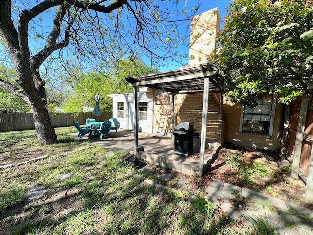 1002 Wrights W, Comanche, TX 76442 - rear view of house with a fenced backyard, a chimney, a patio, a pergola, and brick siding