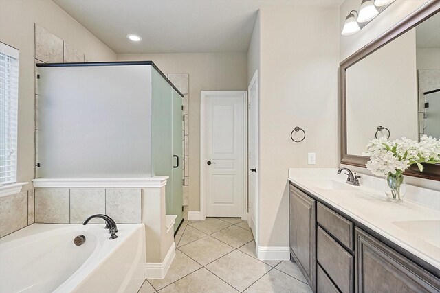 9117 Conroe Dr, Denton, TX 76226 - bathroom featuring a shower stall, a garden tub, tile patterned floors, double vanity, and baseboards