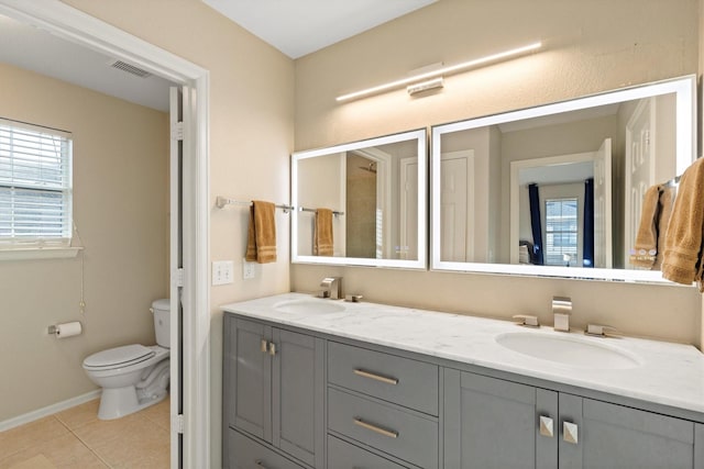 152 Leonard St, Lewisville, TX 75057 - bathroom featuring toilet, double vanity, plenty of natural light, and tile patterned flooring