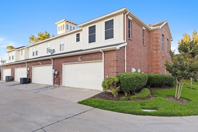 152 Leonard St, Lewisville, TX 75057 - view of front facade with board and batten siding, central air condition unit, brick siding, and an attached garage