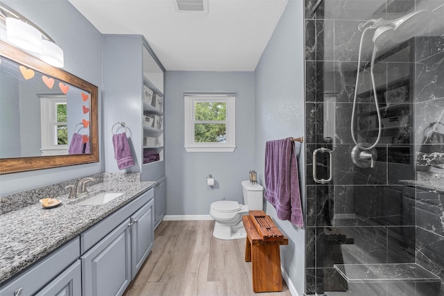 3917 N 31st St, Waco, TX 76708 - bathroom with toilet, vanity, a stall shower, wood finished floors, and baseboards