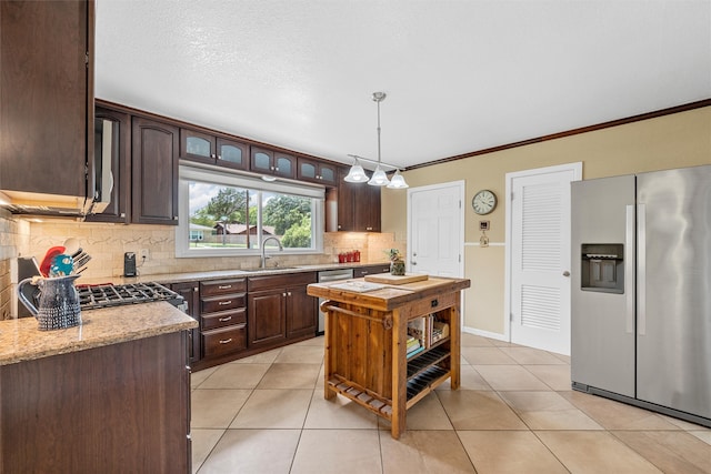 3917 N 31st St, Waco, TX 76708 - kitchen with stainless steel appliances, a sink, dark brown cabinets, backsplash, and light tile patterned floors