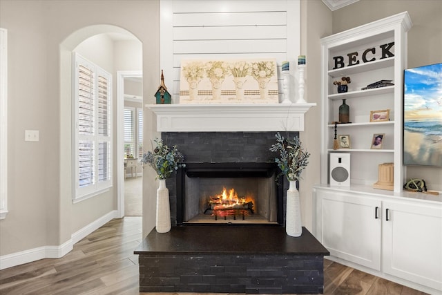 2141 Vanderbilt Dr, Weatherford, TX 76088 - detailed view of a tile fireplace, wood finished floors, arched walkways, and baseboards